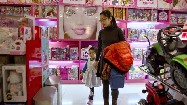 A woman and child walk at a store in Beijing. Picture: Ng Han Guan