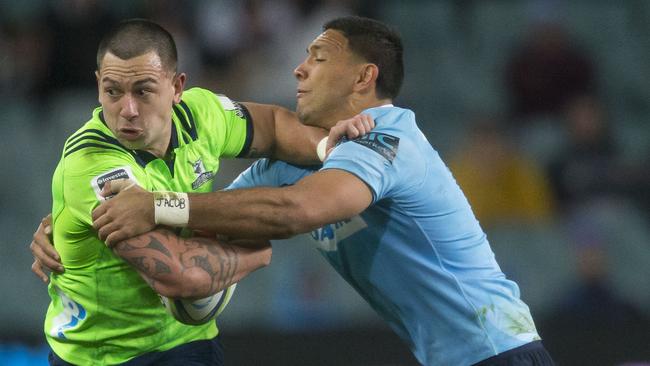 The Waratahs’ Curtis Rona tackles Rob Thompson of the Highlanders on Saturday night.