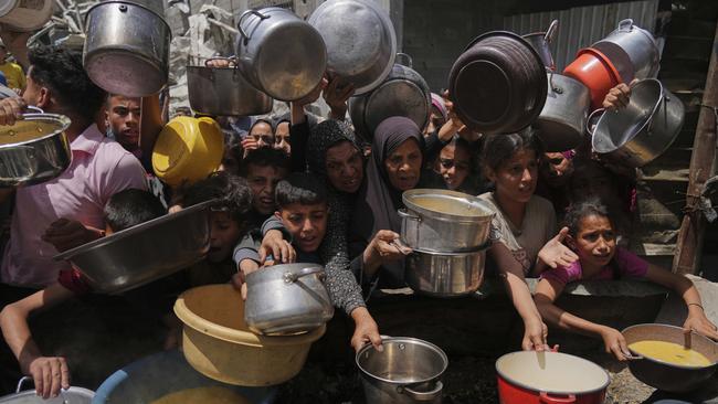 Palestinians struggle to get donated food at a community kitchen in Jabalia, northern Gaza Strip. Picture: AP Photo