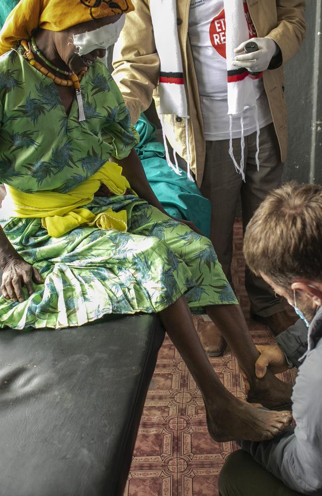 Joel helps Melia with her shoes after her surgery. Picture: Michael Amendolia/Fred Hollows Foundation