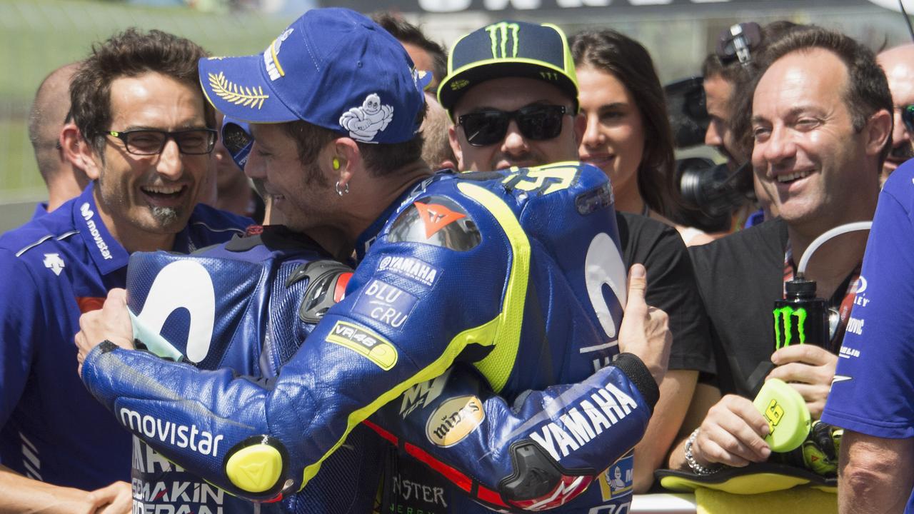 Valentino Rossi is embraced after taking pole in Italy.