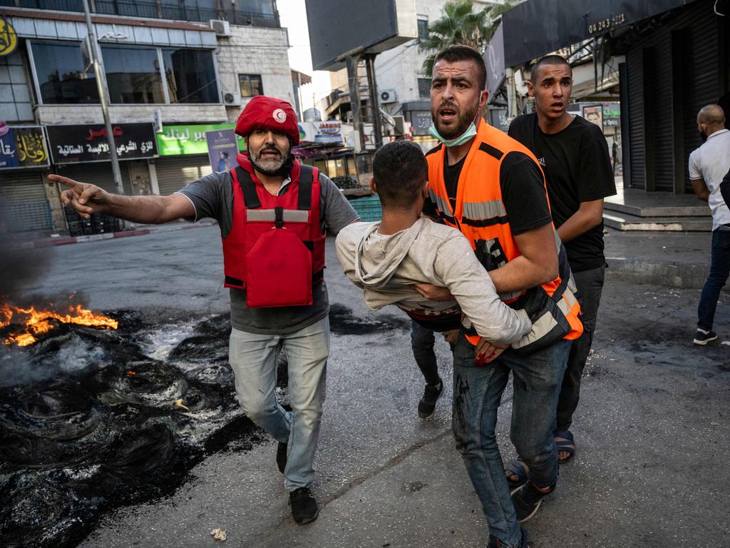 An injured man is carried away after being reportedly shot by Israeli forces during confrontations with them in the occupied West Bank city of Jenin. Picture: Aris Messinis / AFP