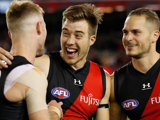 MELBOURNE, AUSTRALIA - MAY 23: (L-R) Nick Hind, Zach Merrett and David Zaharakis of the Bombers celebrate during the 2021 AFL Round 10 match between the Essendon Bombers and the North Melbourne Kangaroos at Marvel Stadium on May 23, 2021 in Melbourne, Australia. (Photo by Michael Willson/AFL Photos via Getty Images)