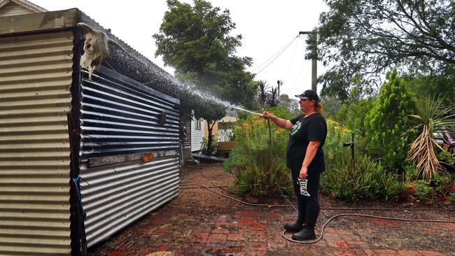 Bruthen resident Kerri Strickland prepares her home for a possible ember attack. But she’ll leave if the fire makes its way into town. Aaron Francis/The Australian