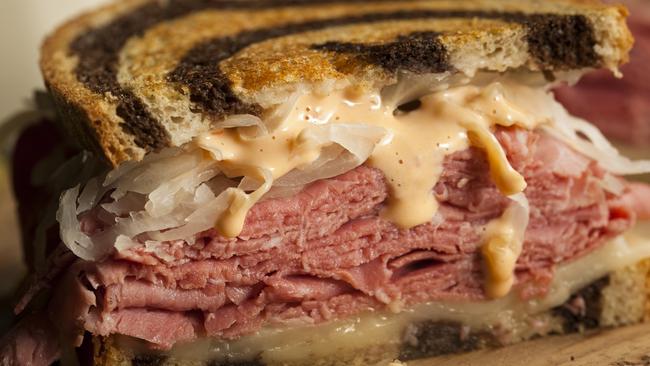 A homemade Reuben sandwich with corned beef and sauerkraut.