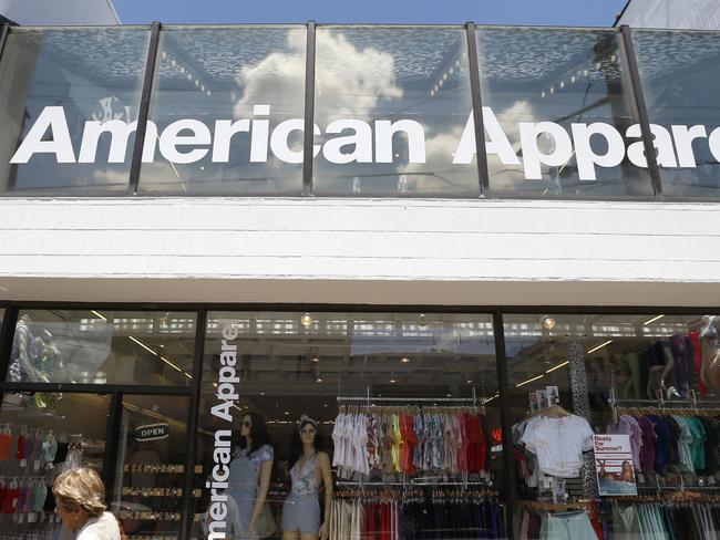 Passers-by walk down the street past the American Apparel store in the Shadyside neighborhood of Pittsburgh on Wednesday, July 9, 2014. American Apparel Inc. has reached a preliminary deal with investment firm Standard General to receive $25 million in financing to bolster the clothing chain’s finances, according to a person close to the negotiations.(AP Photo/Keith Srakocic)