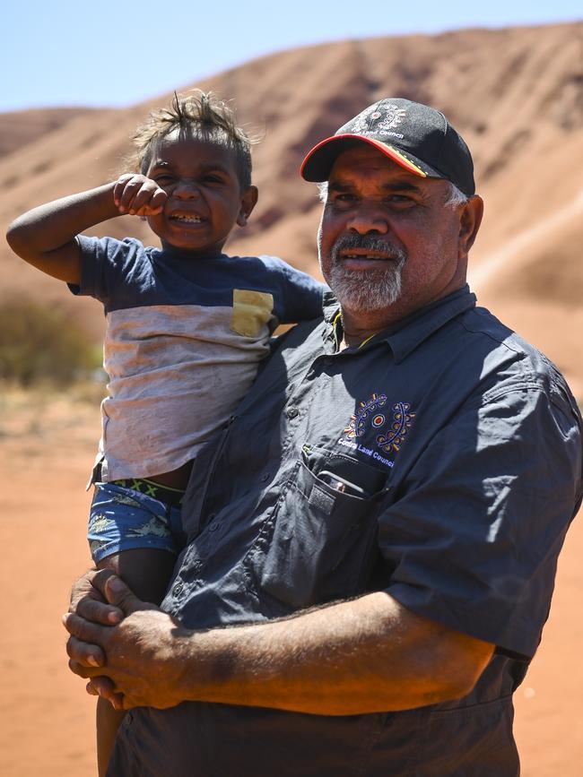 Sammy Wilson, chair of the Central Land Council and his grandson Jacob in front of Uluru.`