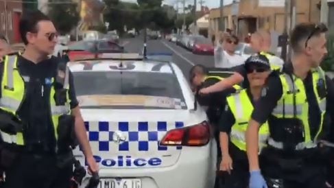 Police place a hand-cuffed man in the back of a car after arresting him at the Brunswick Music Festival. Picture: Marc Peckham video