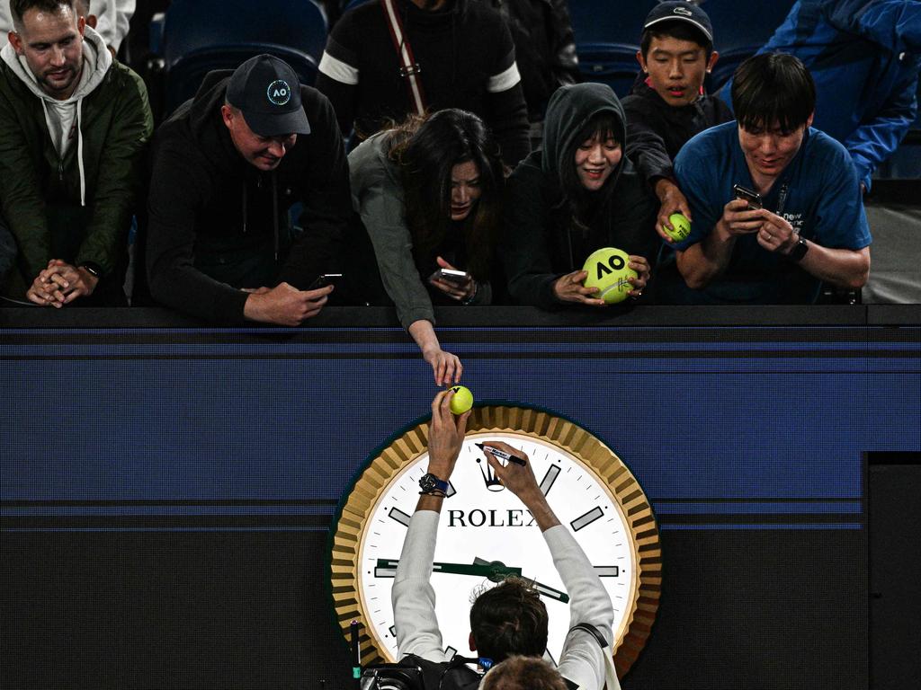 Russia's Daniil Medvedev signs autographs above the clock as he leaves the court after victory against Finland's Emil Ruusuvuori in their men's singles match on day five of the Australian Open. Picture: AFP