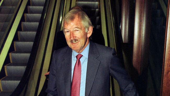 Ron Brierley walks down an escalator while leaving the annual meeting for Tyndall Aust Ltd in 1998. Picture: David Gray/Reuters