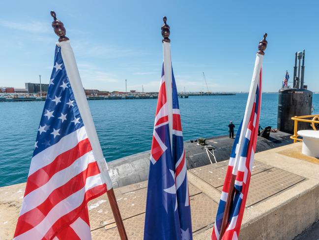 National flags of the USA, Australia and Great Britain are seen in front of the USS Asheville, a Los Angeles-class nuclear powered fast attack submarine, at HMAS Stirling, Western Australia on Tuesday, March 14, 2023. Picture: NCA NewsWire / pool / Richard Wainwright