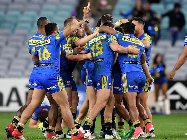 Mitchell Moses is mobbed by Eels teammates after kicking the match winning field goal.