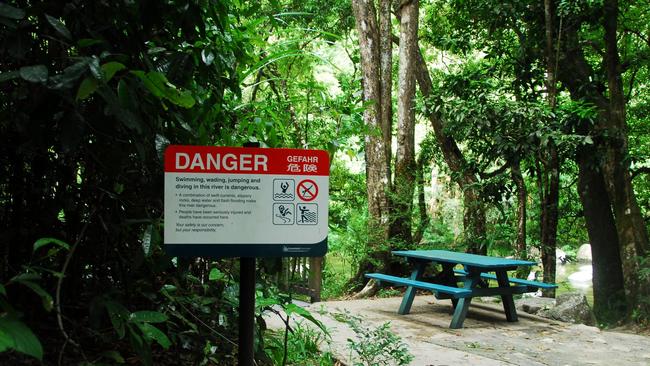 A warning sign metres from where the tourists where swept downstream at Mossman Gorge on Friday.