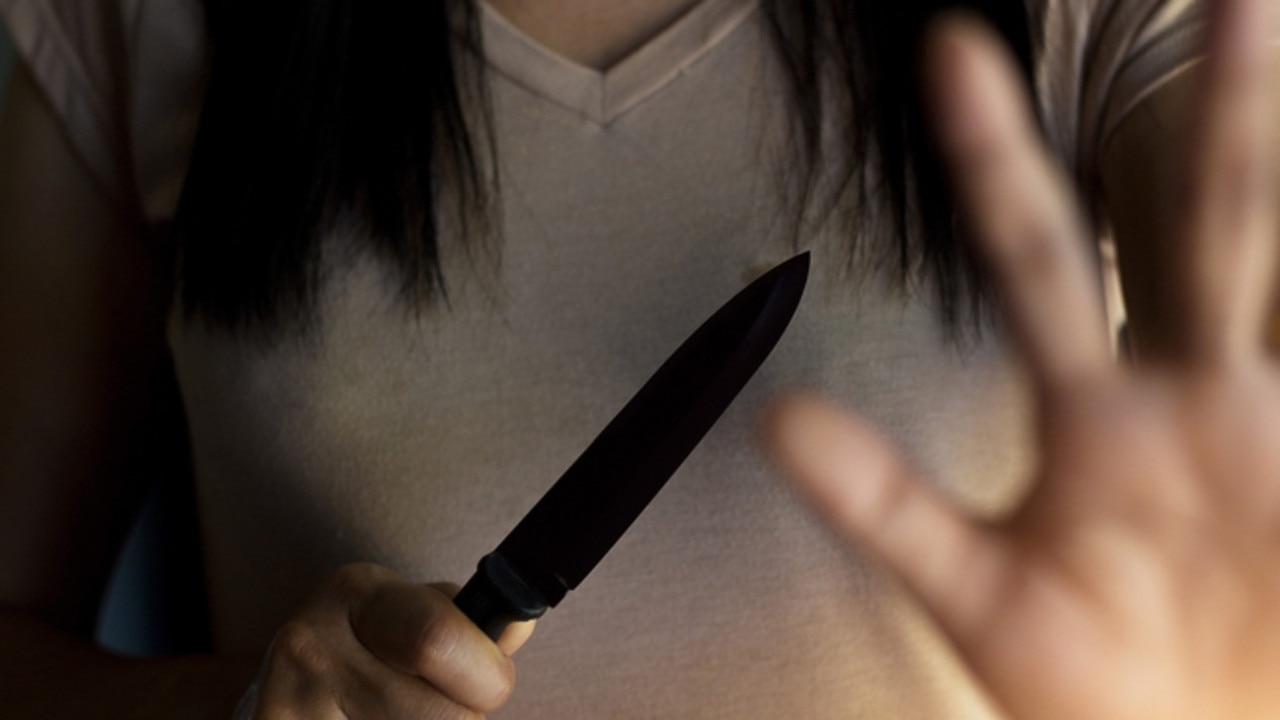 Woman holding a knife in hand while defending herself from attacks. Photo: iStock