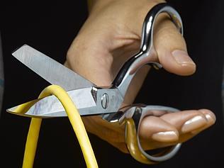 Person cutting ethernet cable between two globes with scissors. Technology, internet, connectivity, wired, shutdown. File sto...