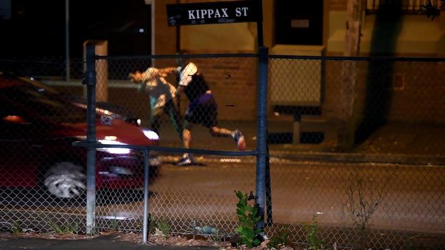 The brawlers continue fighting along Kippax Street. Picture: Gordon McComiskie