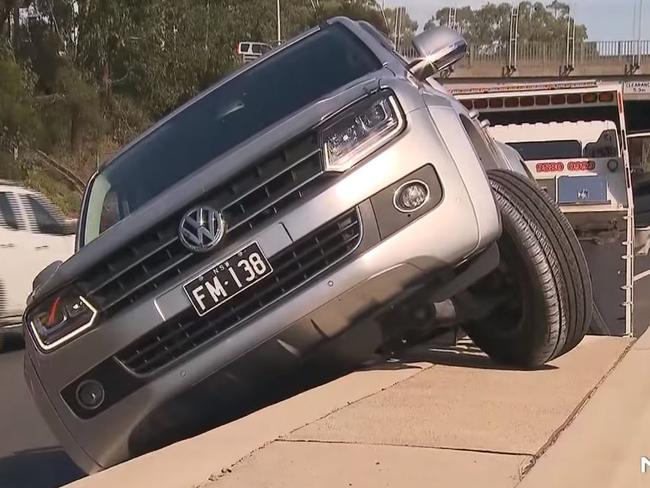 A man has been arrested after driving down the wrong side of the M5 and crashing his ute on a concrete dividing barrier. Picture: Channel 7