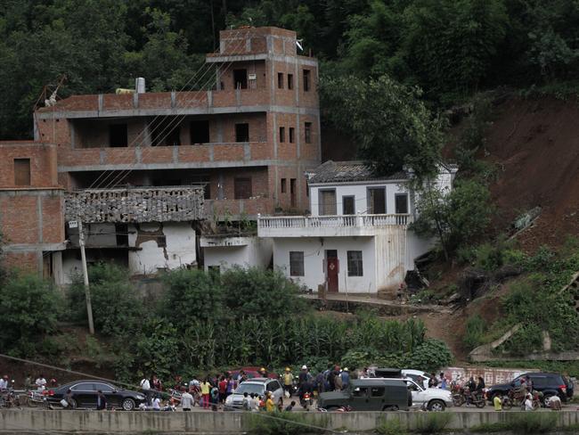 Residents gather near damaged houses following the earthquake. AFP PHOTO/STR CHINA OUT