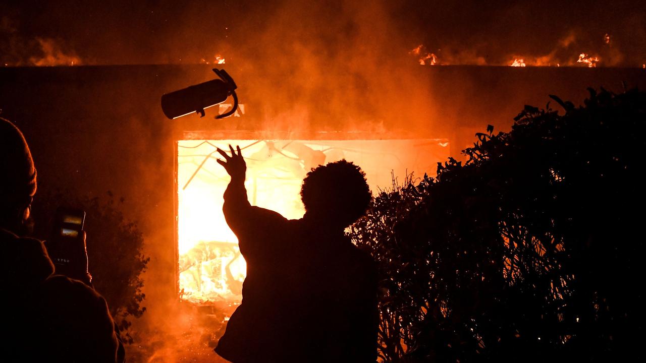 A protester throws a fire extinguisher in a burning building in Minneapolis. Picture: Chandan Khanna / AFP