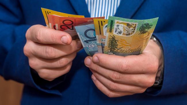 Male hands holding australias dollar banknotes closeup