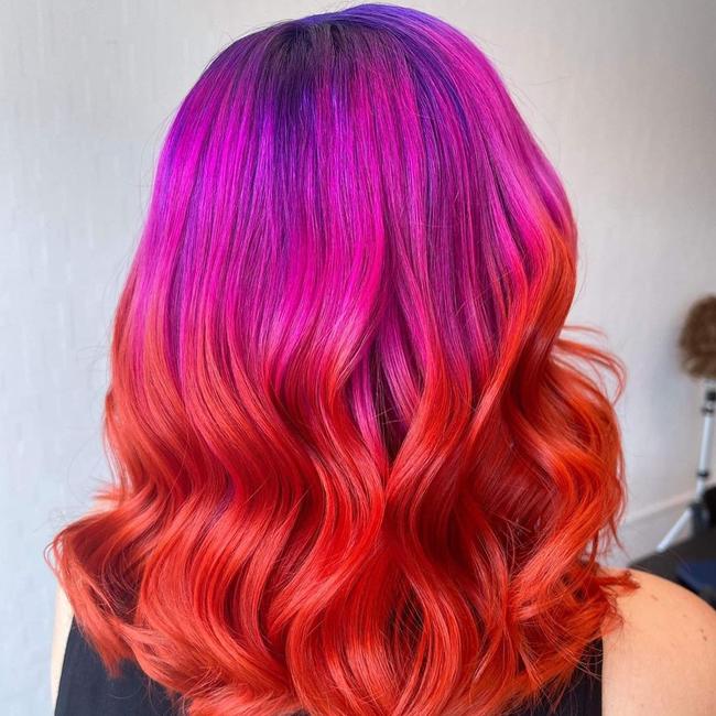 Holly Sharpe is crazy for colour. Pink and red wavy medium-length hair that melts right into each other.