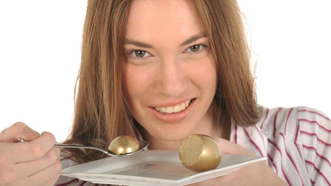 Your Money superannuation generic images. Woman eating golden nest egg with spoon from plate.