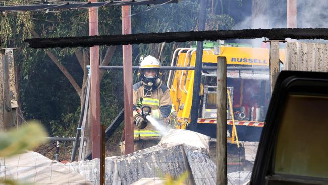 A firefighter dampens the scene. Picture: Steve Pohlner