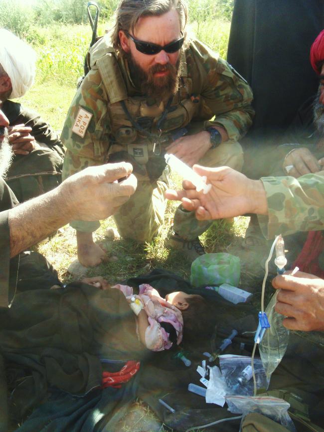 Voodoo Medic Dan Pronk helps administer a drip to a small child.