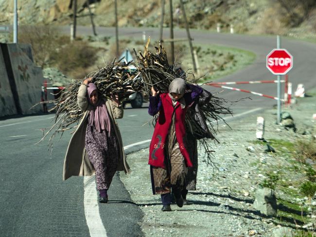 Women carry firewood along a road in the Tajik Darvoz District on the border with Afghanistan. Picture: AFP