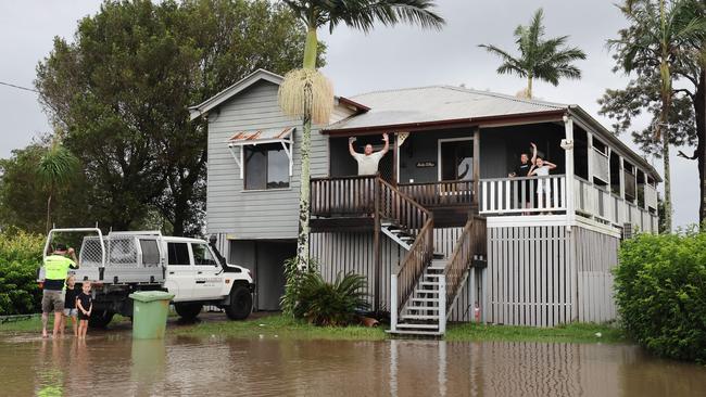 Flooding on the Gold coast in the aftermath of Cyclone Alfred. Stapylton homes surrounded by floodwaters..Leigh Kerslake and family watch the water with their jetski tied to the letterbox Picture Glenn Hampson