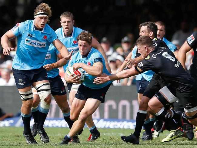 Waratahs Michael Hooper (C) breaks through the Sharks defensive line.