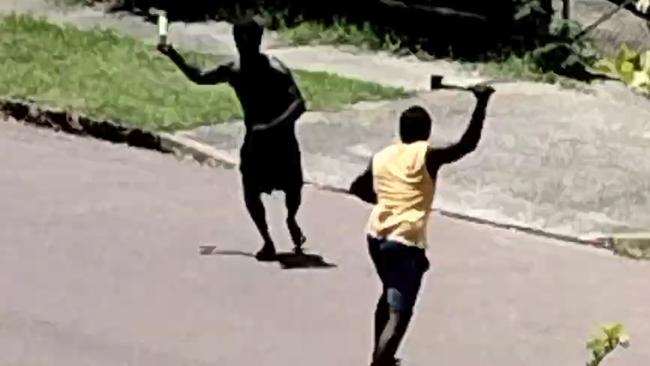 More than a dozen men and women, with their children watching on, ran at each other in the suburban Darwin street wielding tomahawk axes and other makeshift weapons on Friday.