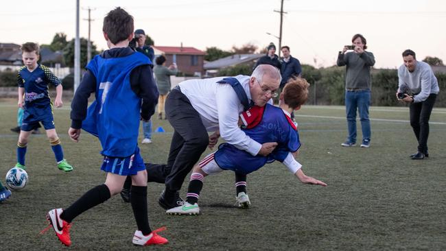 Scott Morrison trips and falls on to Luca during training. Picture: Jason Edwards