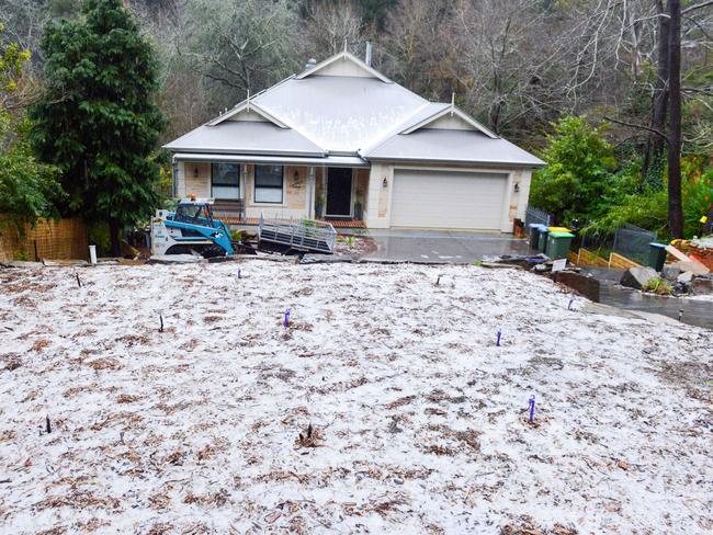 Hail covers the ground at a house near Stirling in the Adelaide Hills on Monday. Picture: AAP / Brenton Edwards