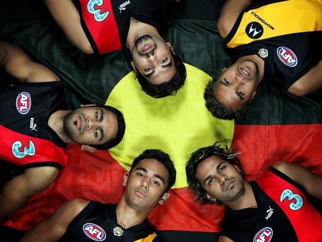 Essendon's Nathan Lovett-Murray, Dean Rioli and Andrew Lovett and Richmond's Richard Tambling and Andrew Krakouer with the Aboriginal flag to promote the NAIDOC Dreamtime at the 'G match.
