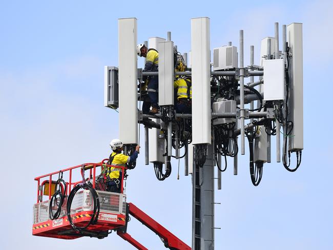 Telecommunications workers are seen working on a mobile cell tower, at West Ryde, in Sydney, Wednesday, March 25, 2020. (AAP Image/Dan Himbrechts) NO ARCHIVING