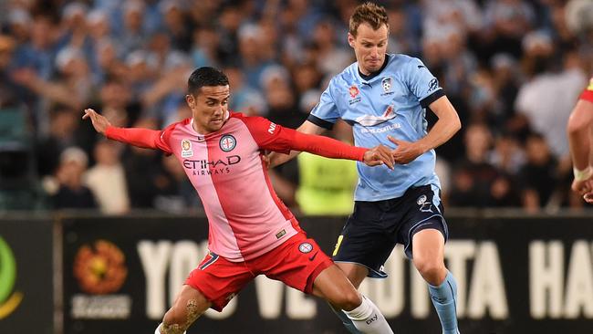 City's Tim Cahill and Sydney's Alex Wilkinson contest the ball.