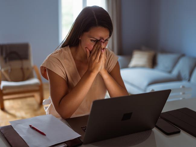 Female victim of financial fraud, looking anxious. She is at her home, discovering financial fraud; scams, scammer generic