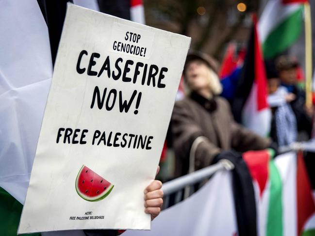 Pro-Palestinian sympathizers shout slogans and wave placards as they stage a rally outside the International Court of Justice (ICJ) in The Hague on January 12, 2024, prior to the hearing of the genocide case against Israel, brought by South Africa. Israel said that it was not seeking to destroy the Palestinian people, as it hit back at what it called a "profoundly distorted" and "malevolent" genocide case against it at the UN's top court.  South Africa has launched an emergency case at the International Court of Justice (ICJ) arguing that Israel stands in breach of the UN Genocide Convention, signed in 1948 in the wake of the Holocaust. (Photo by Koen van Weel / ANP / AFP) / Netherlands OUT