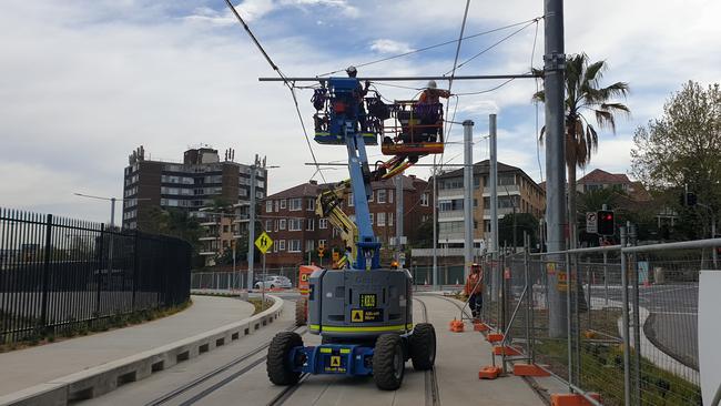 Workers have started installing the light rail power poles.