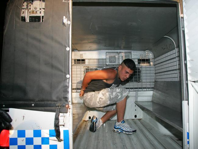 A man sits in paddy wagon after being arrested outside Northie’s pub in Cronulla.