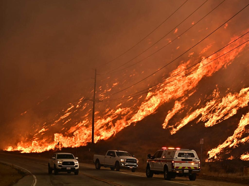 Emergency vehicles are on the side of the road as flames from the Hughes fire race up the hill in Castaic. Picture: AFP