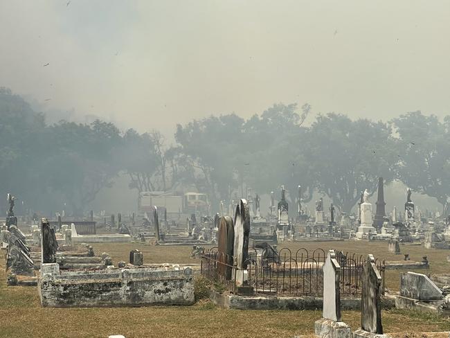 Smoke can be seen through the cemetery, as crews fight the nearby fire. Picture: Fergus Gregg