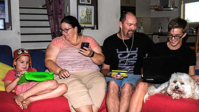 Gympie West's Micah, Kathy, Rob and Mitchell Pitt, with their dog Winston, enjoying their devices through the National Broadband Network. Picture: Jacob Carson