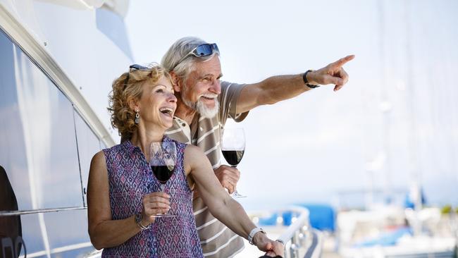 Happy senior couple enjoying wine on yacht. seniors and retirees travel, holidays, generic