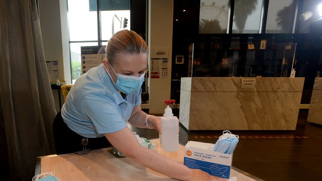 Healthcare staff clean the check-in area. Picture: Andrew Henshaw