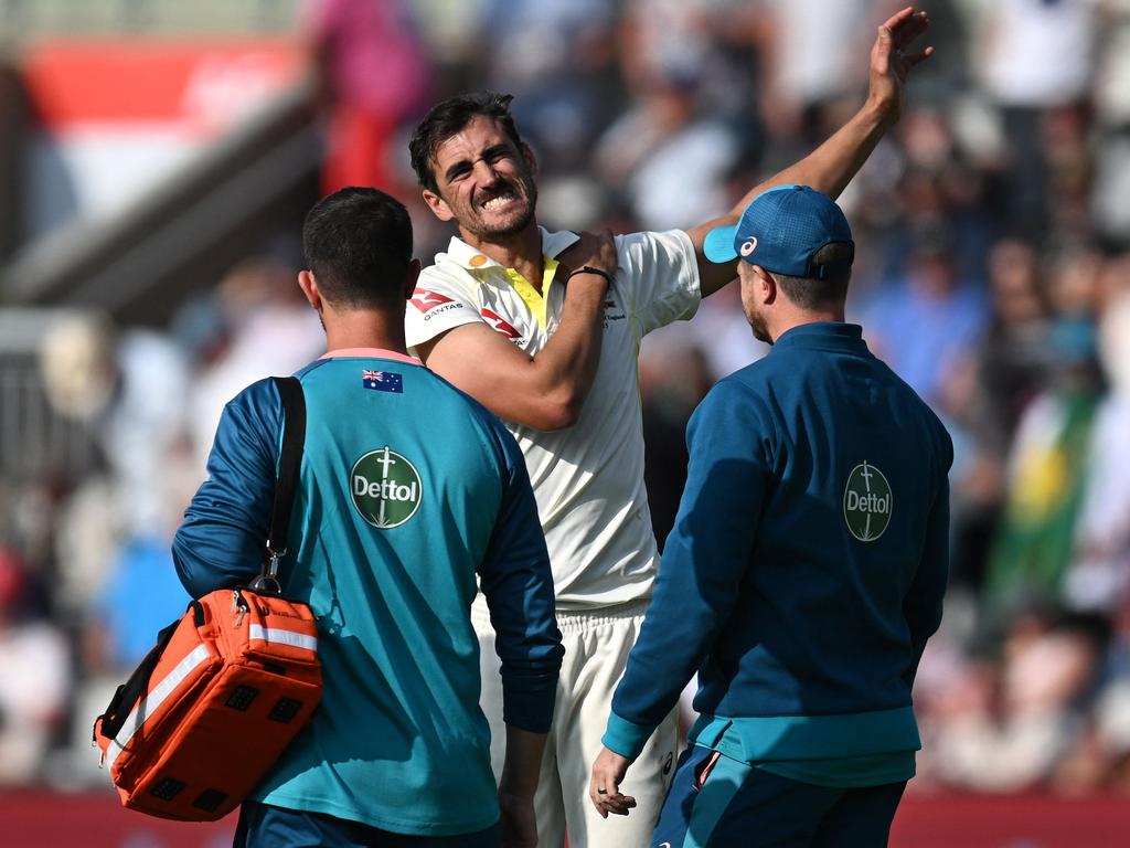 Mitchell Starc (C) receives medical attention after hurting his shoulder at Old Trafford. Picture: Oli Scarff/AFP