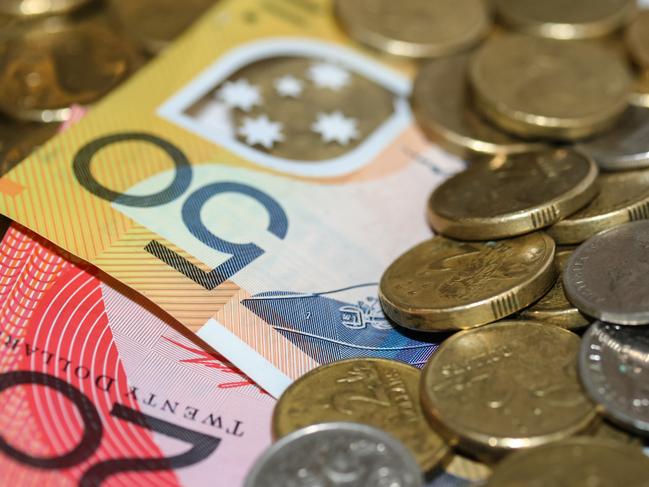 Close up of Australian money, twenty and fifty dollar notes and gold and silver coins scattered on pile.