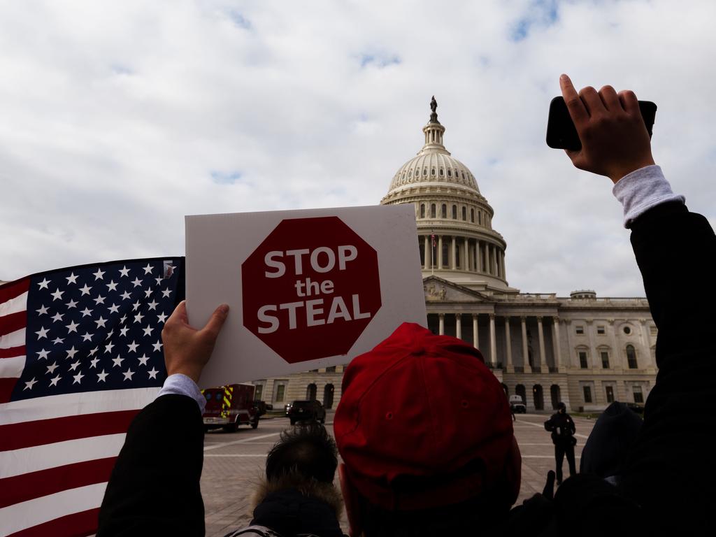 A man holds a ‘Stop The Steal’ sign outside the US Capitol building prior to a group violently storming the building, resulting in five deaths. Picture: Jon Cherry/Getty Images/AFP