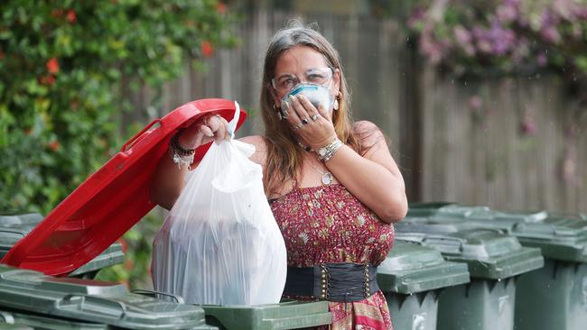 The pungent aroma of prawn heads and meat scraps has been filling the warm, humid air on roadsides around Cairns this week, after the excesses of Christmas Day have passed and the smelliest bin day of the year approaches. Michelle de Ron took some extra precautions while throwing out a bag full of old prawns, seafood and oyster shells into the kerbside collection in front of her house on Little Street, Manunda. Picture: Brendan Radke